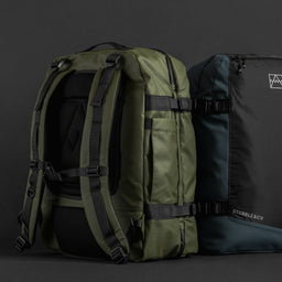 A studio shot of the backpanel on an Urban Green and Blue adventure bag in front of a black background.