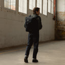 A man walking away wearing a Backpack 20L on his back in All Black