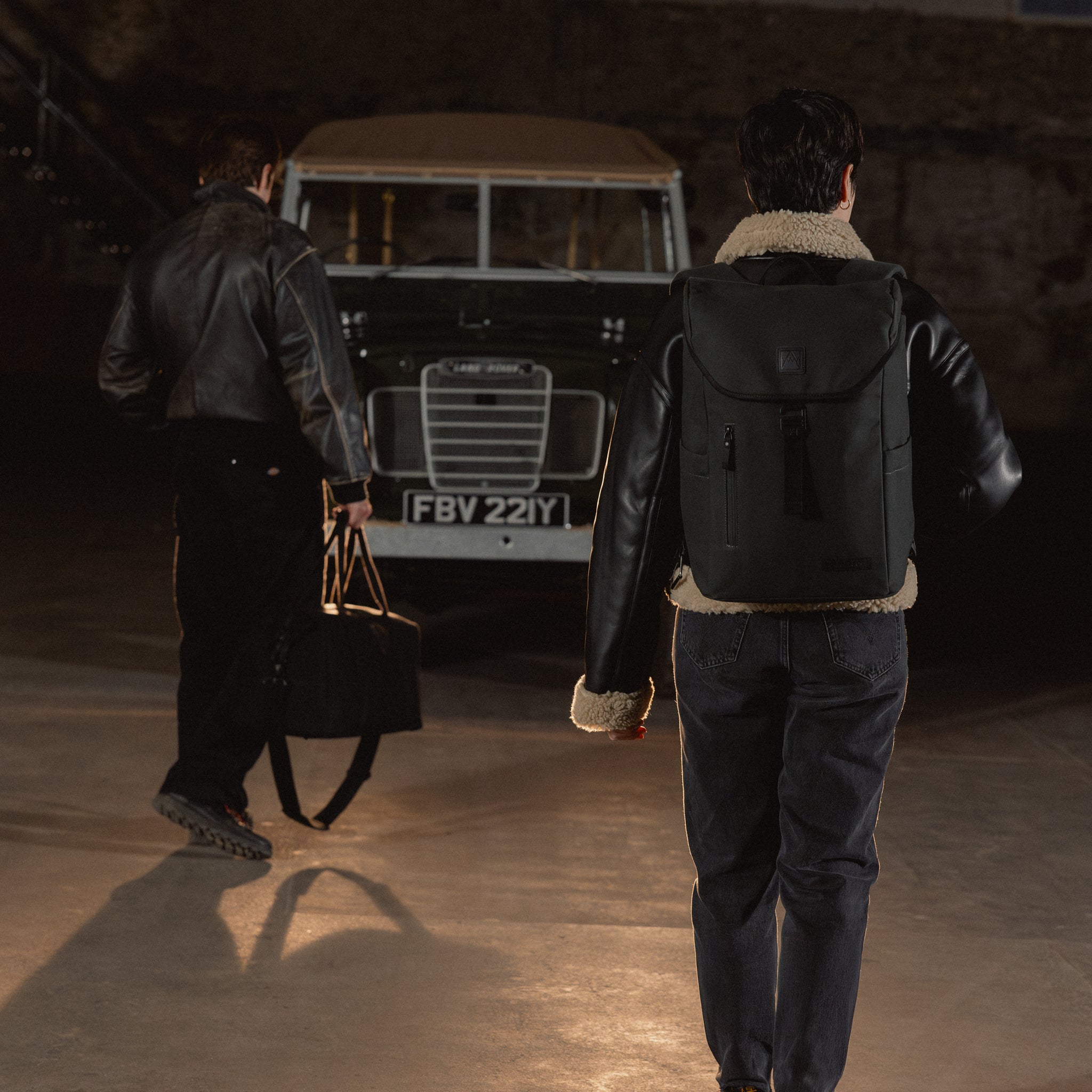 A man and woman walking towards a car with a Backpack 20L on her back in All Black