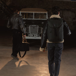 A man and woman walking towards a car with a Backpack 20L on her back in All Black