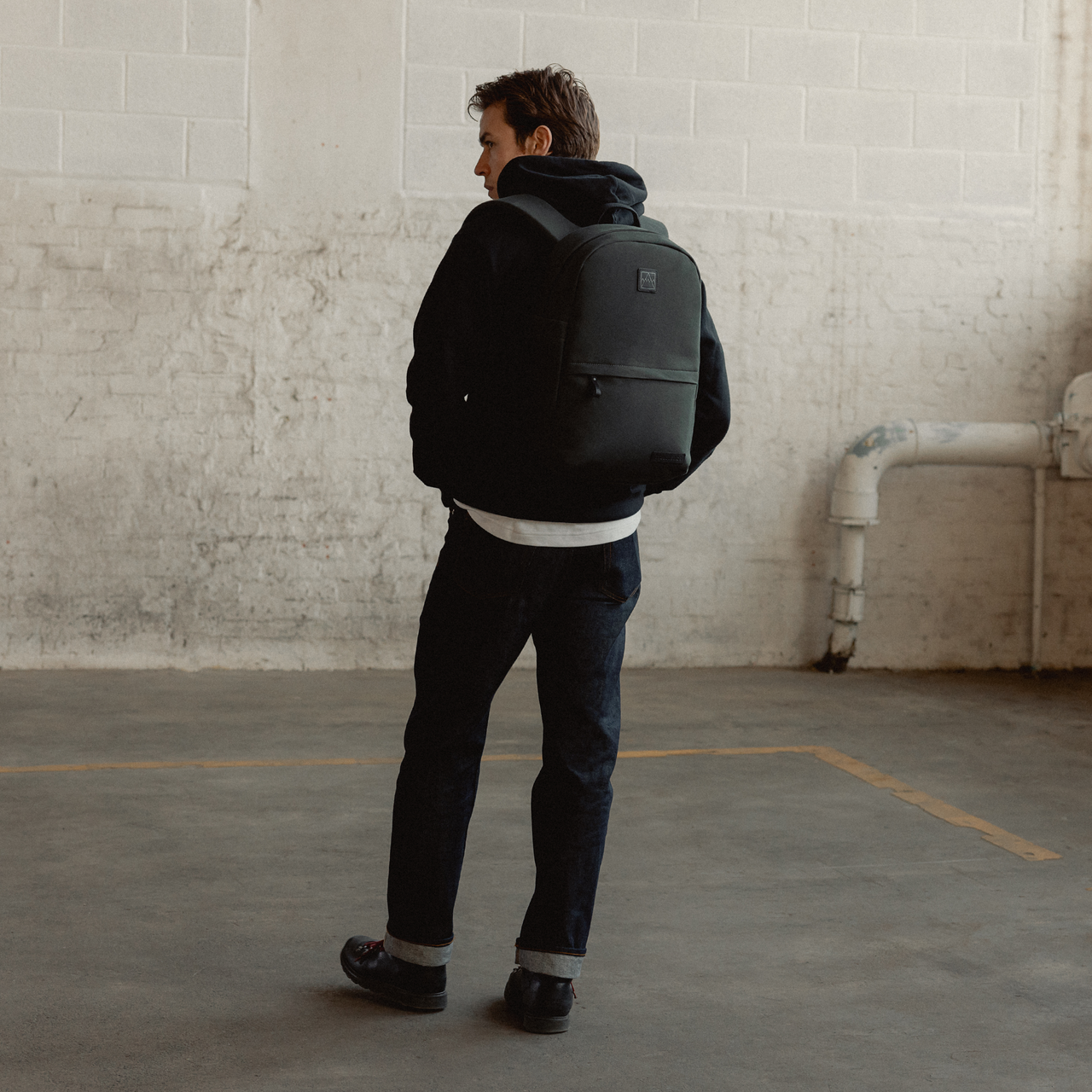 A man facing away wearing a Classic Backpack 15L in Pirate on her back