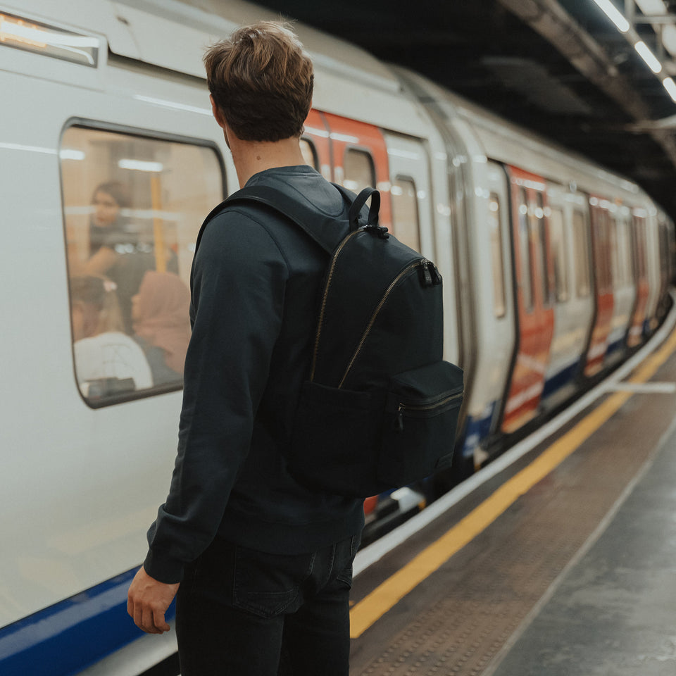 The Commuter Backpack in Black and Gold by train