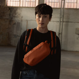 A woman wearing a Roll Top and Crossbody in Rust