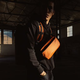 A man wearing a Roll Top and Crossbody in Rust