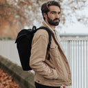 A man wearing an All Black Daypack Outlet on his back