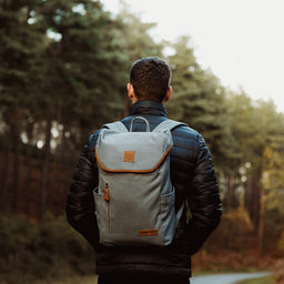 A man wearing a Grey Daypack Outlet on his back in the forest