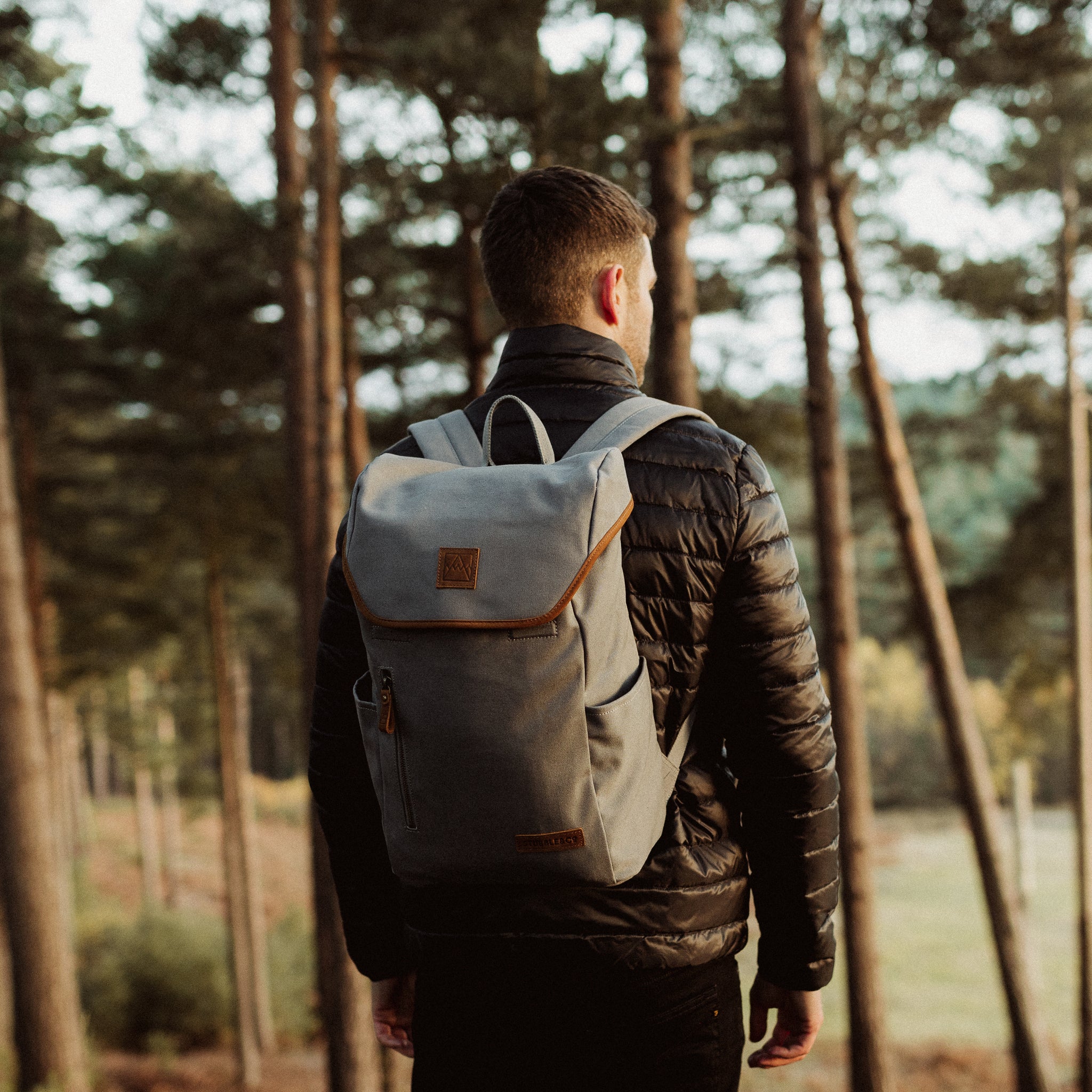 A man wearing a Grey Daypack Outlet on his back in the forest