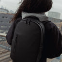 A close up of an Everyday Backpack 15L in All Black on a woman's back