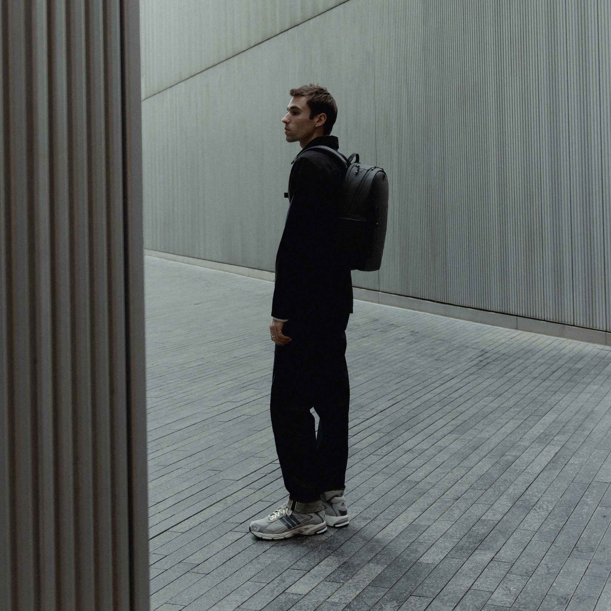 A man wearing an Everyday Backpack 15L on his back in All Black