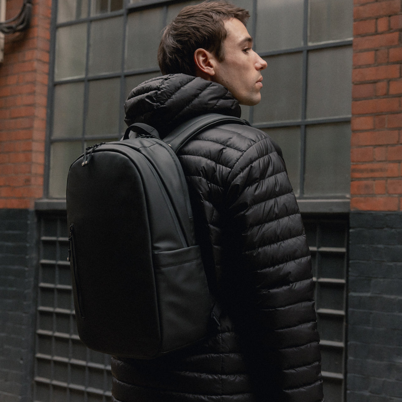 A man wearing an Everyday backpack 15L on his back in All Black