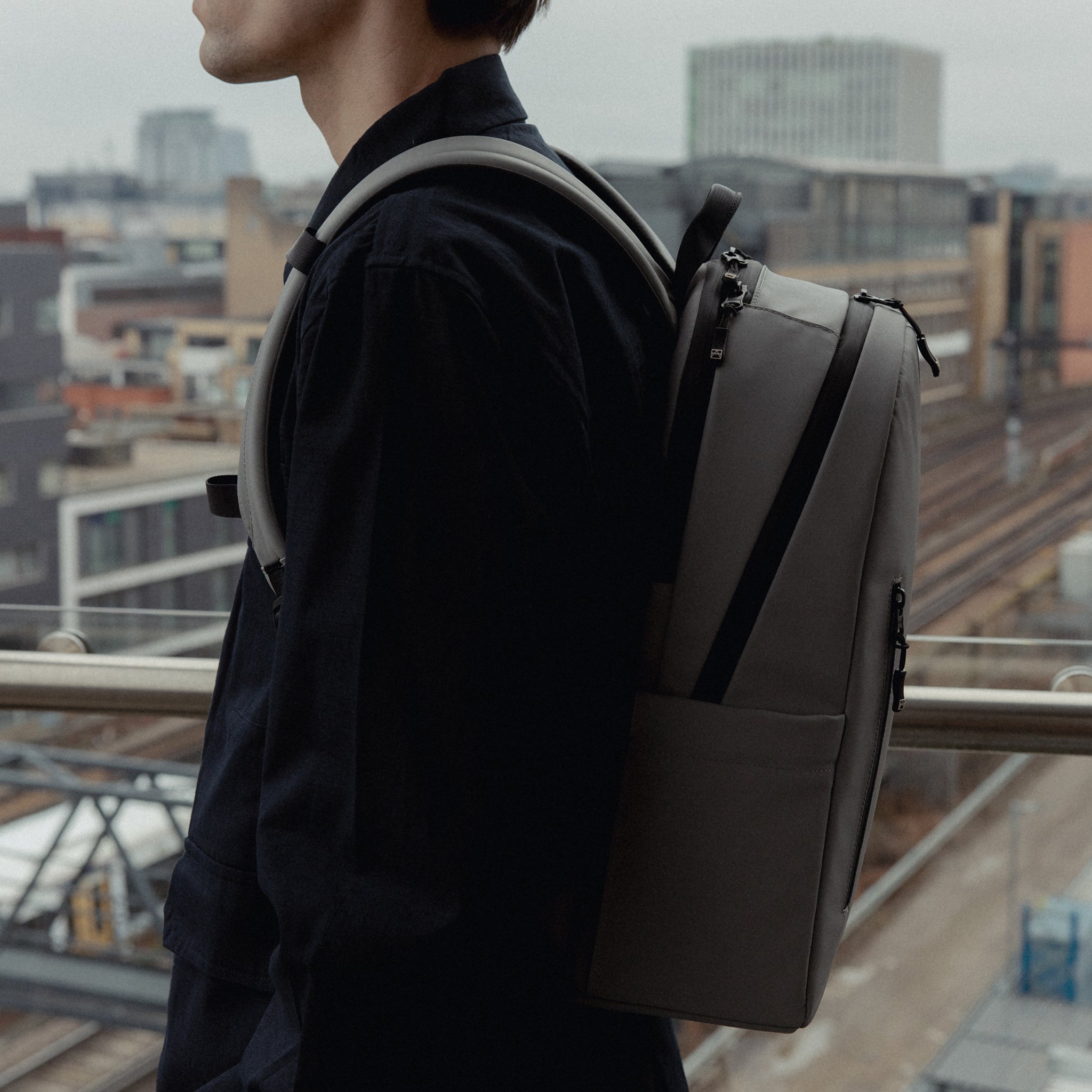 A close up of the side of an Everyday Backpack 15L in Concrete on a man's back