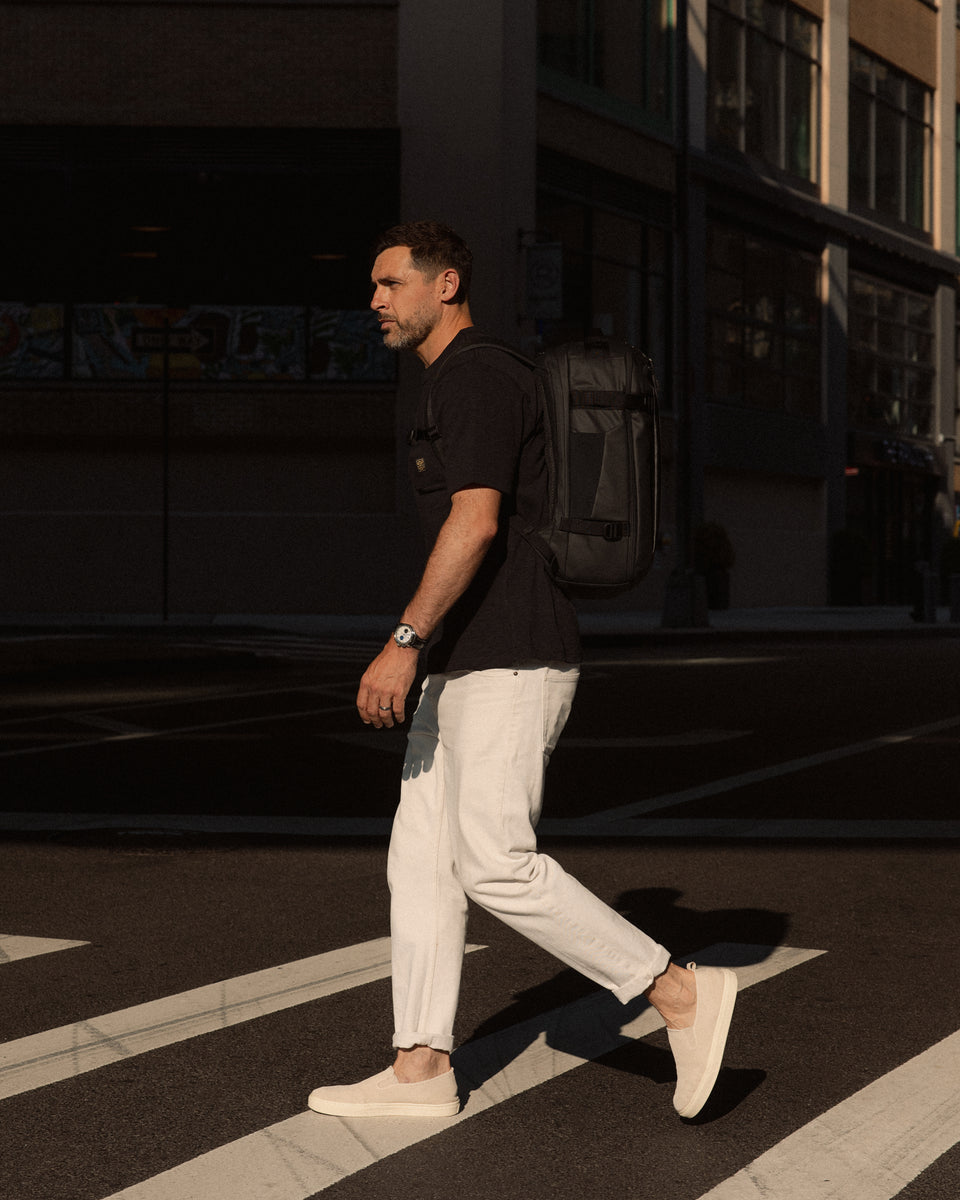 a man crossing a zebra crossing in New York wearing a Hybrid Backpack 30L on his back