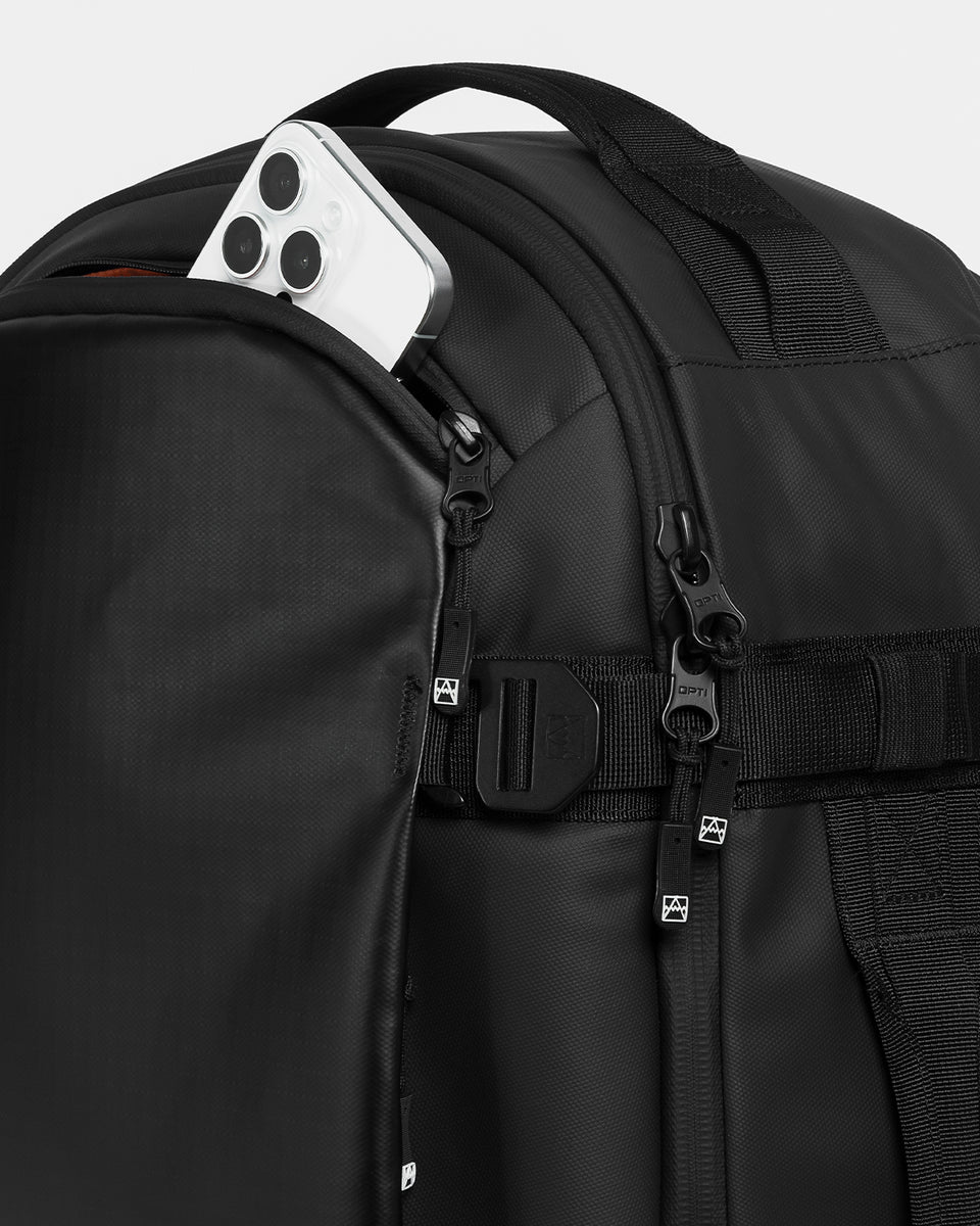 A studio shot of the Hybrid Backpack 30L and its dual access pocket at the top with phone in it