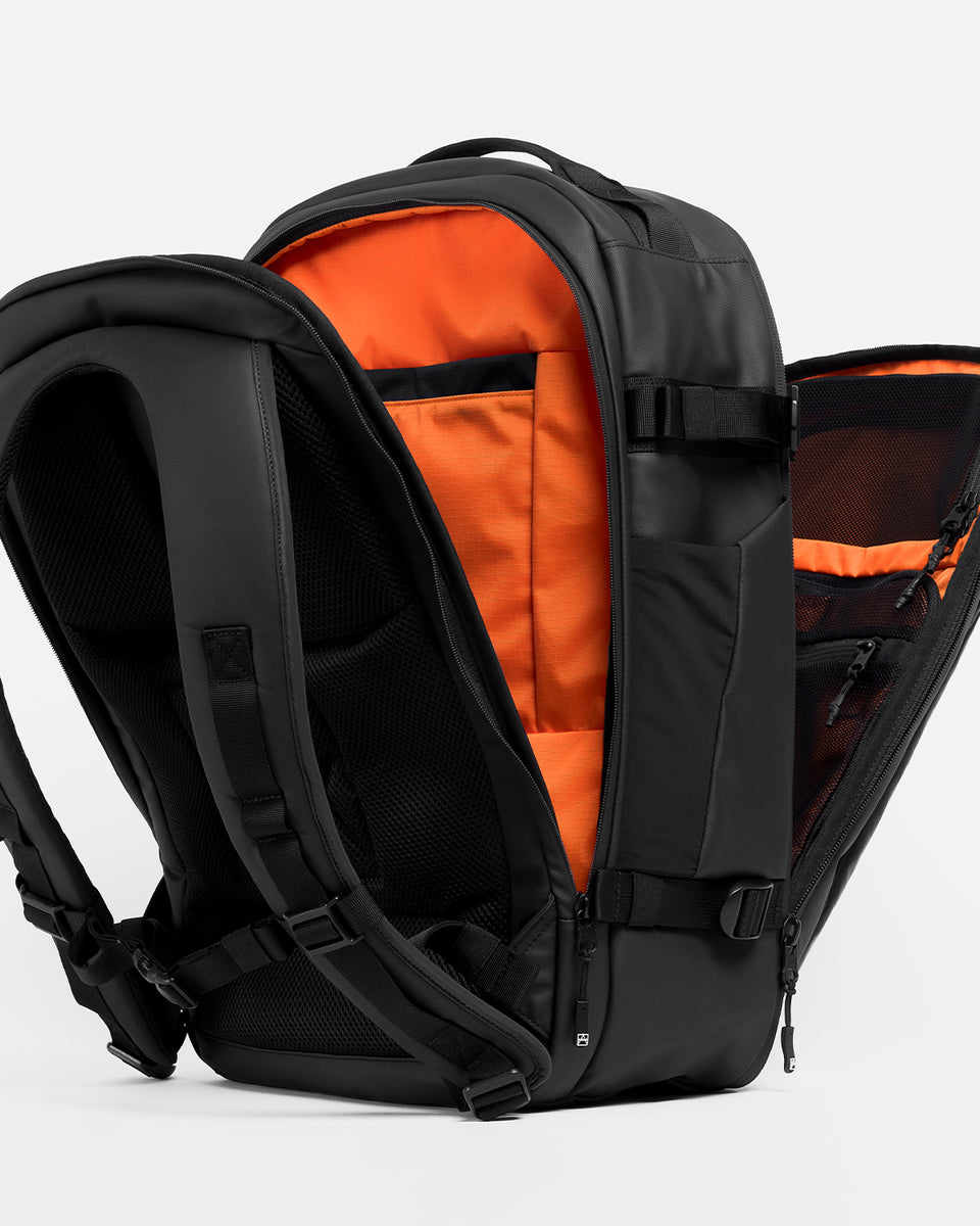 A studio shot of the Hybrid Backpack 30L and its split compartments with the orange lining