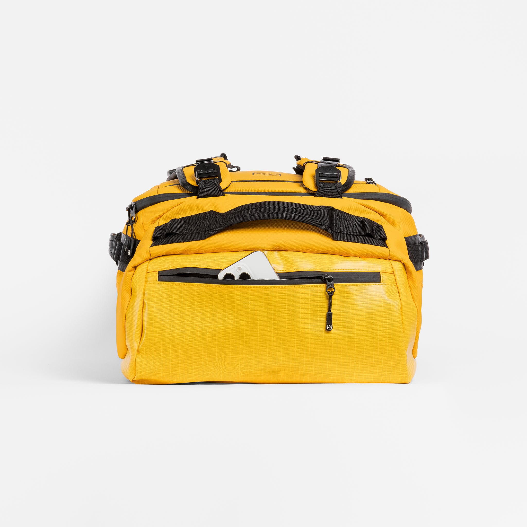 A studio shot of the end pocket with a phone in on the Kit Bag 30L in Yellow