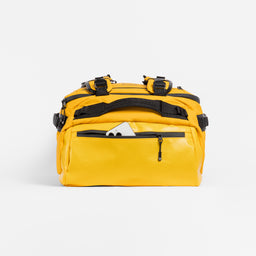 A studio shot of the end pocket with a phone in on the Kit Bag 30L in Yellow