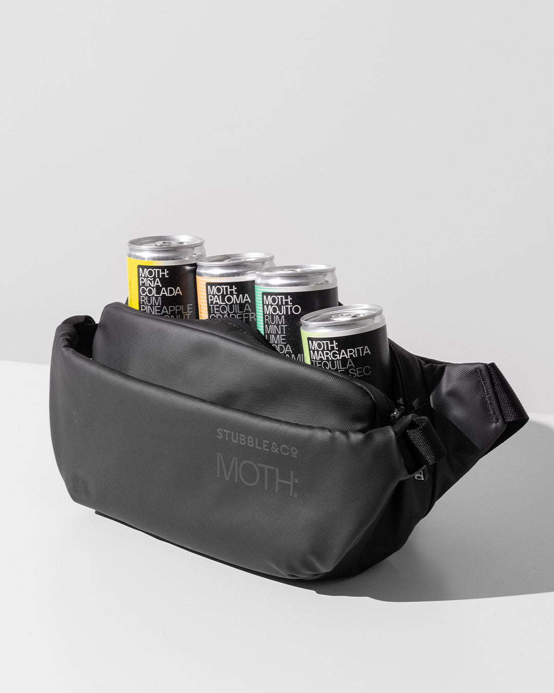 A studio shot of the front of the MOTH X Stubble & Co Crossbody Cooler with MOTH cocktails inside