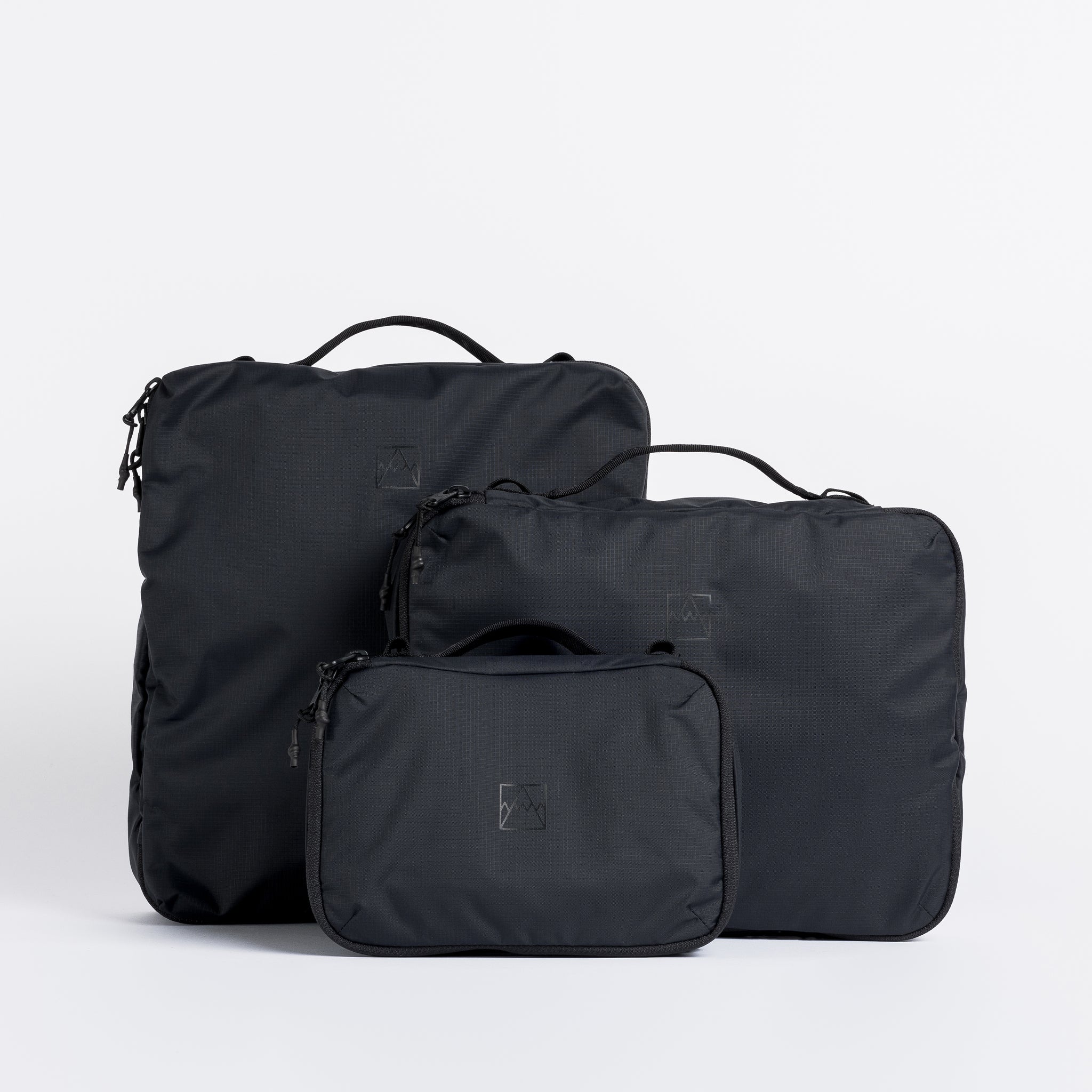 A studio shot of the packing cubes sizes together in All Black