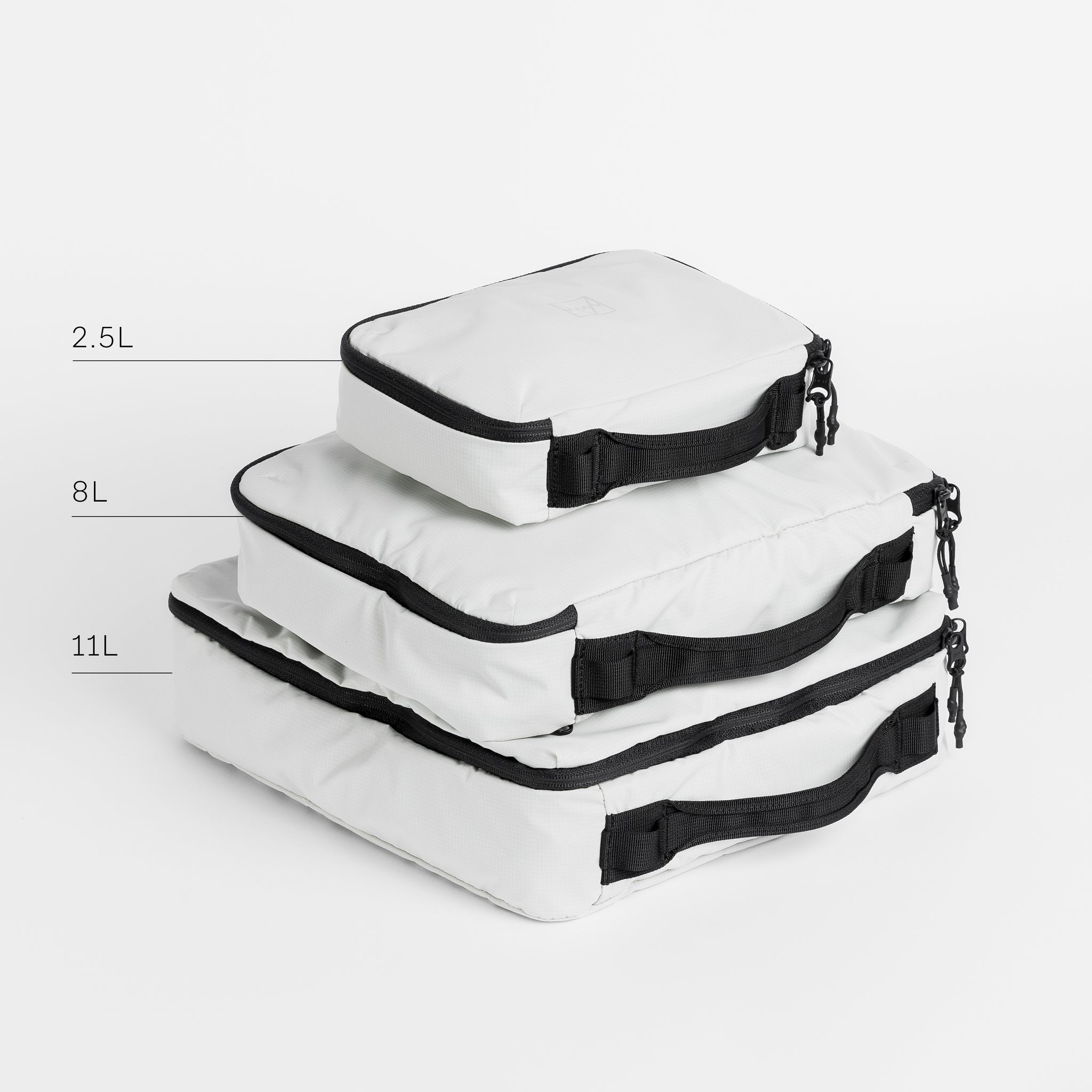 A stack of white packing cubes in all 3 sizes with the capacity annotated [All Variants]