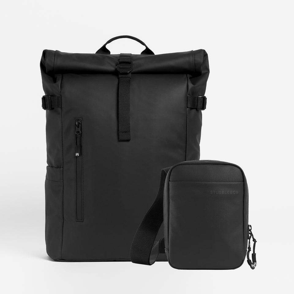 A studio shot of a Roll Top 20l in All Black / All Black Shoulder Bag