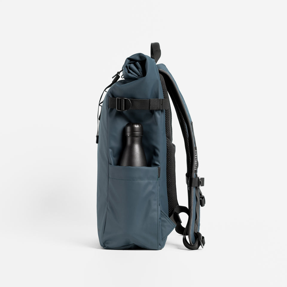 Side view of The Roll Top 20L backpack in Tasmin Blue