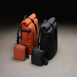 A studio creative of a Roll Top and Shoulder bag in black and Rust