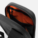 A studio shot of the orange interior lining and pockets in an All Black shoulder bag