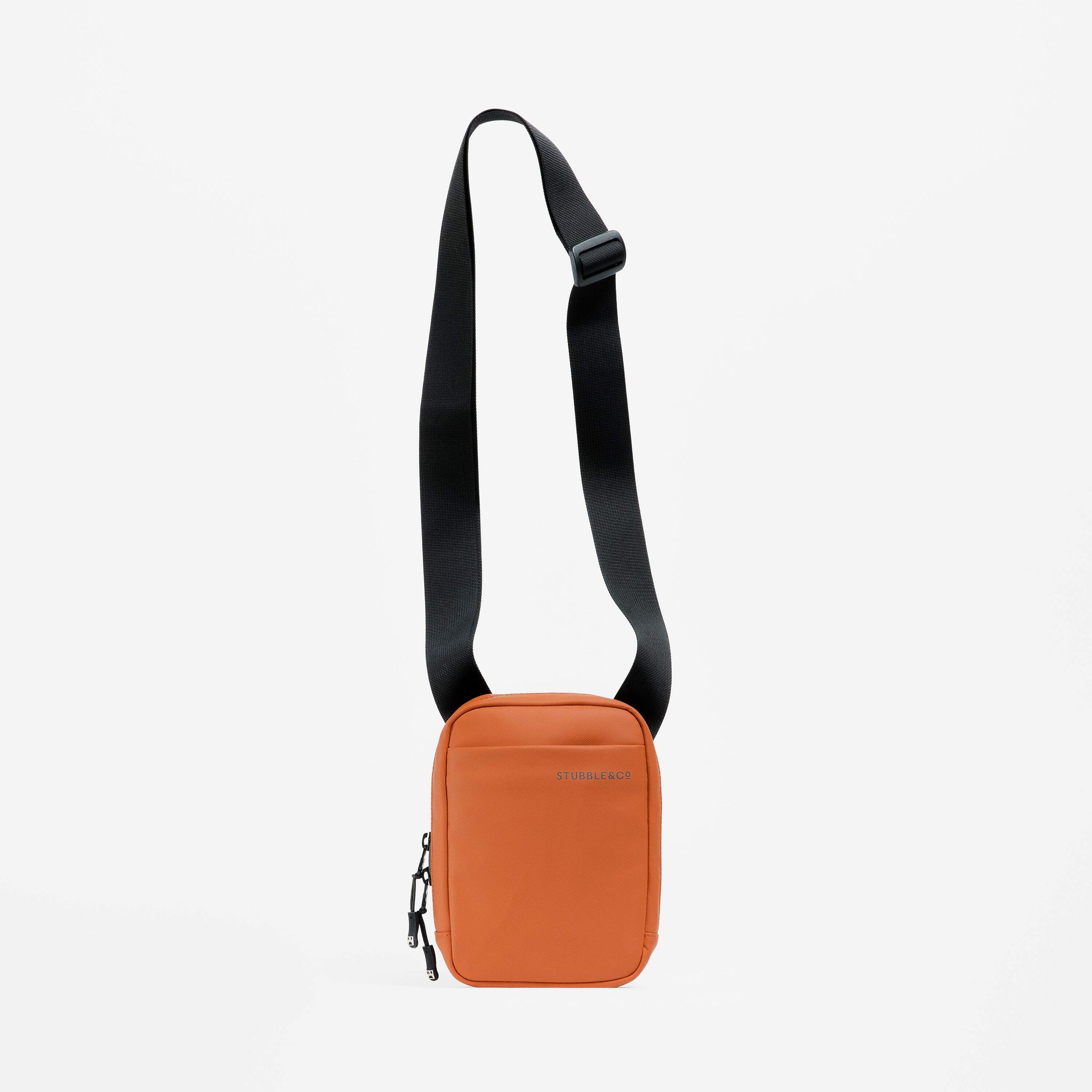 A studio shot of the Shoulder Bag in Rust with the strap hanging