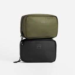 A studio shot of a black and Urban Green tech bag stacked on top of eachother