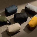 A creative studio shot of all of the Wash Bag colours including the Concrete