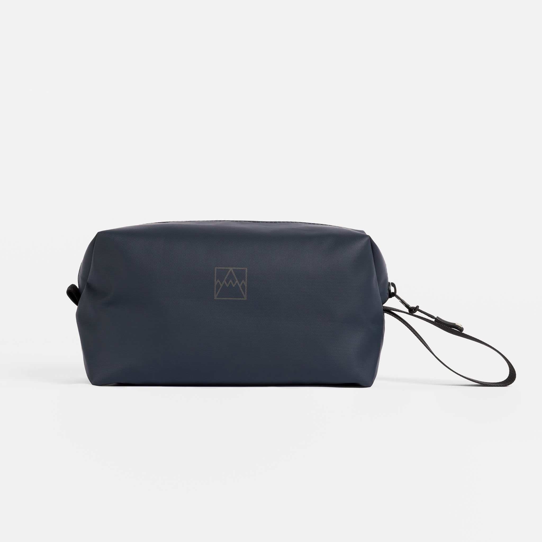 A studio shot of the logo on the side of a Wash Bag in Midnight Blue