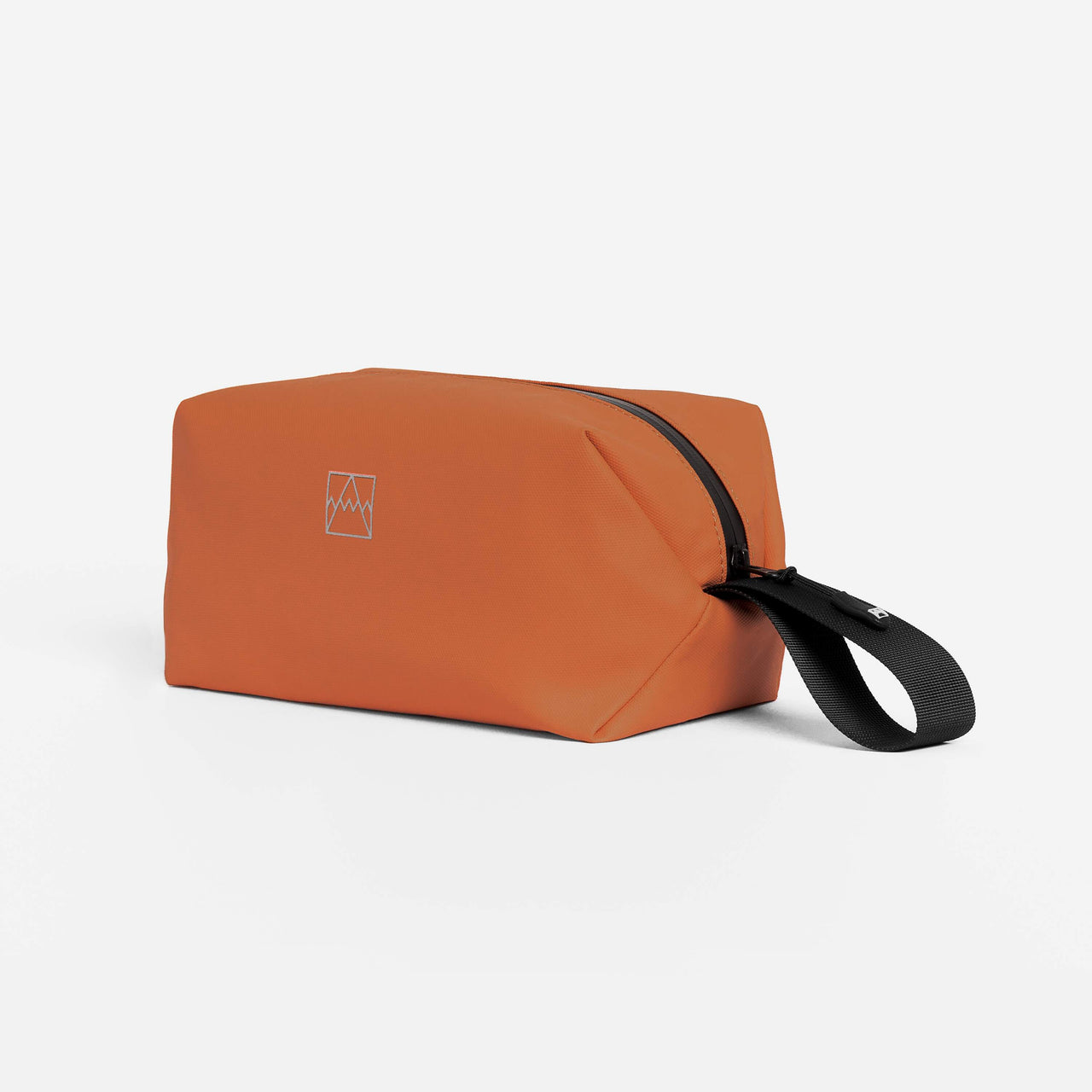 A studio shot of the side of the Wash Bag in Rust showing the reflective branding