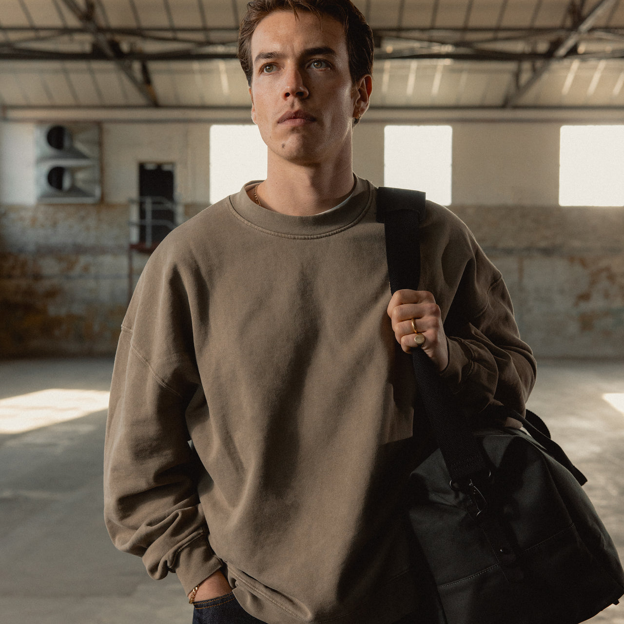 A man facing the camera wearing a weekender 30l in Pirate on his shoulder