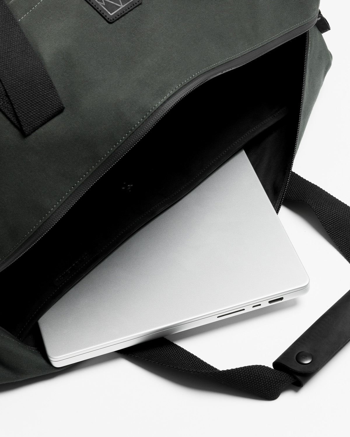 A laptop inside the laptop compartment in the weekender duffel 30l