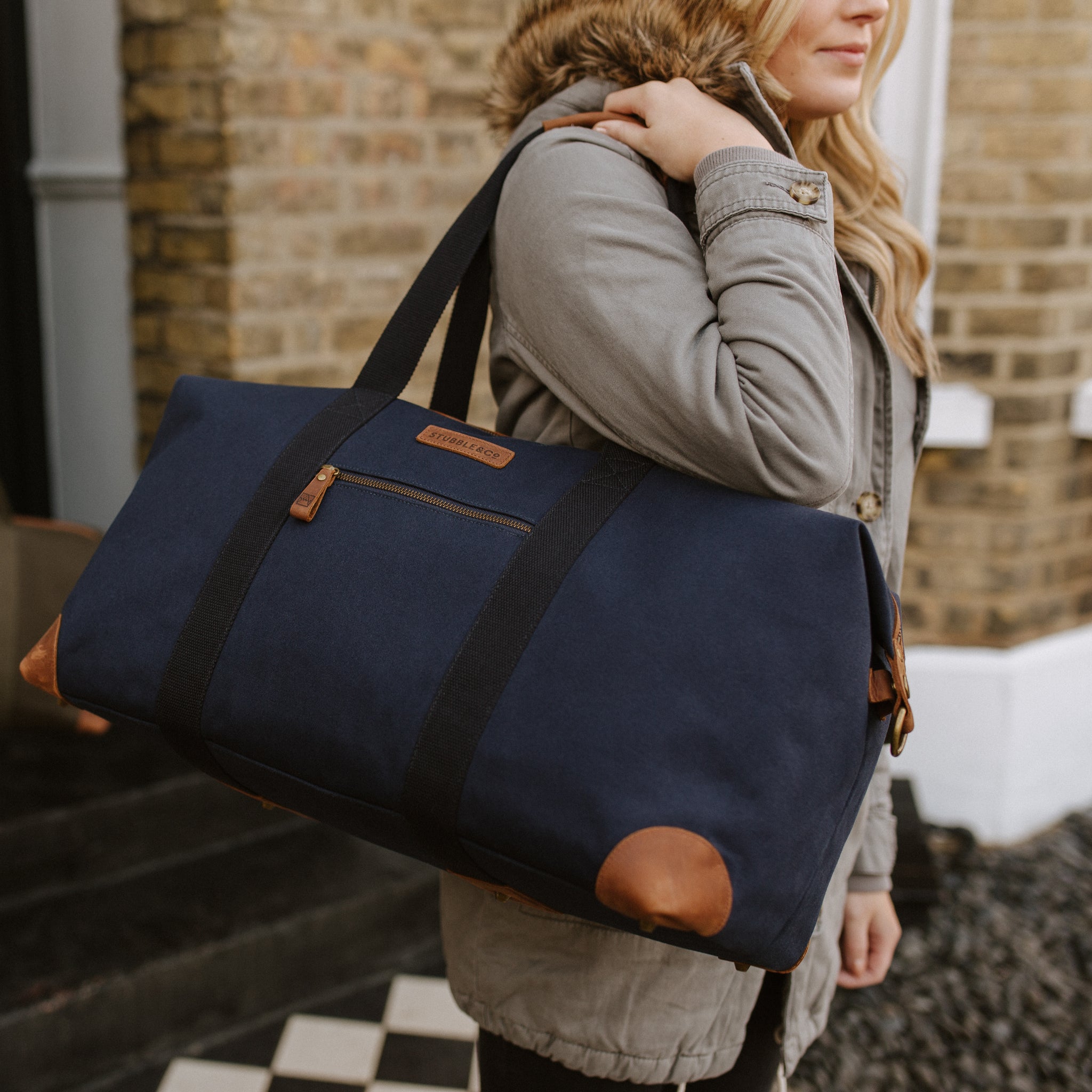 A woman carrying a Weekender Outlet in Navy on her shoulder