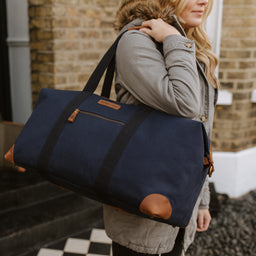 A woman carrying a Weekender Outlet in Navy on her shoulder