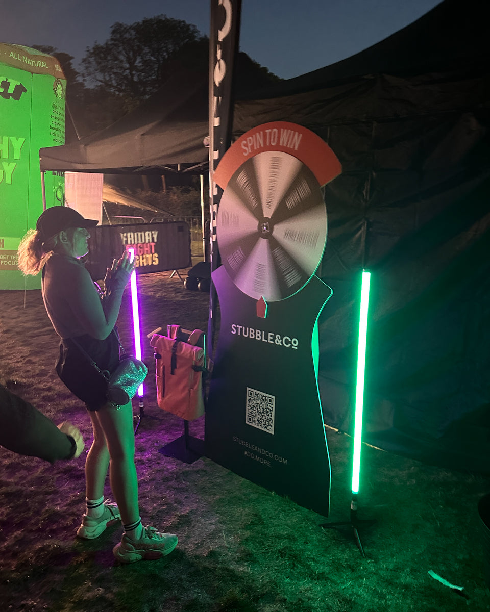 A woman spinning the Stubble & Co wheel at the Friday Night Lights event